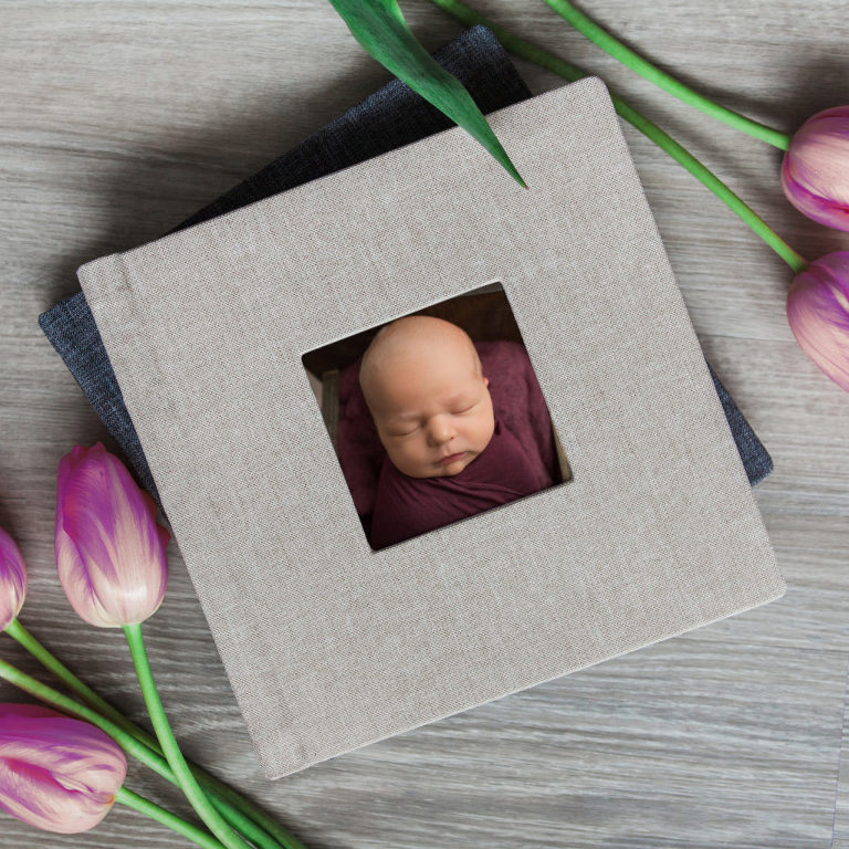 printed portraits in an heirloom baby album with neutral linen cover