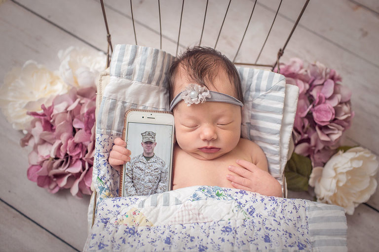 newborn photography baby girl holding deployed dad on telephone