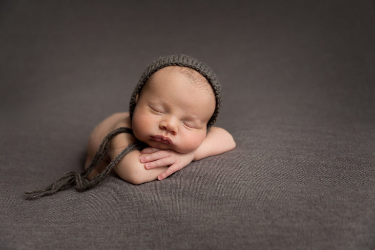 newborn photography baby with brown bonnet