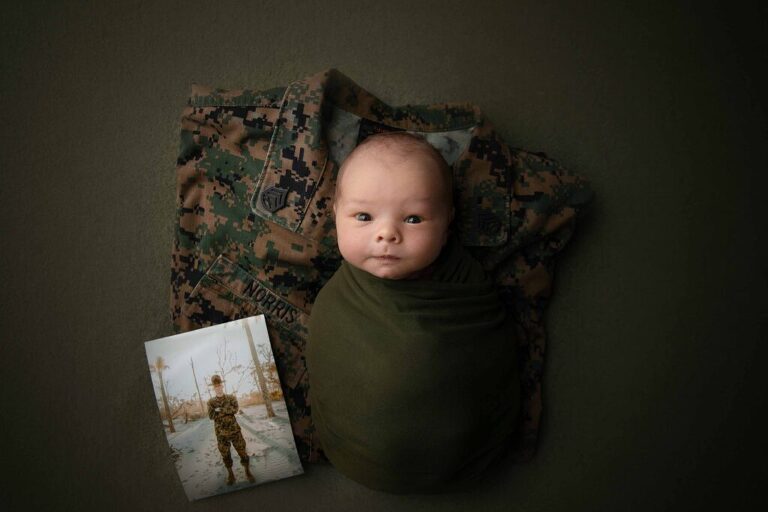 Newborn baby of a deployed marine with his cami stop and a picture