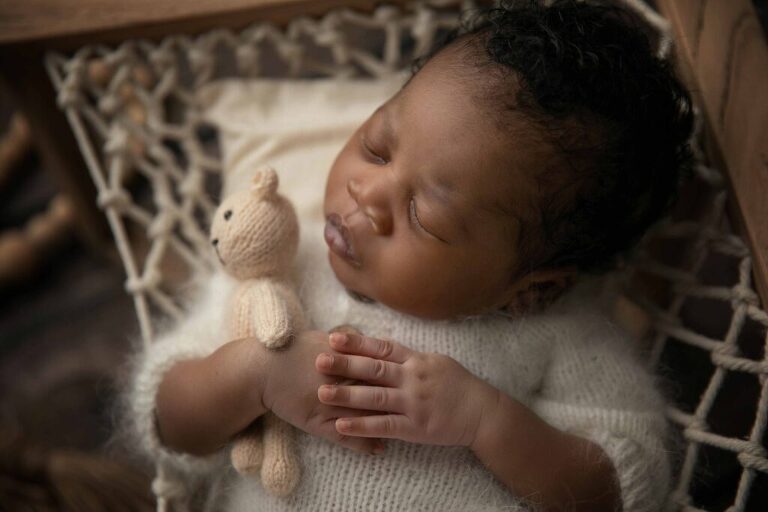 Newborn baby holding a stuffy