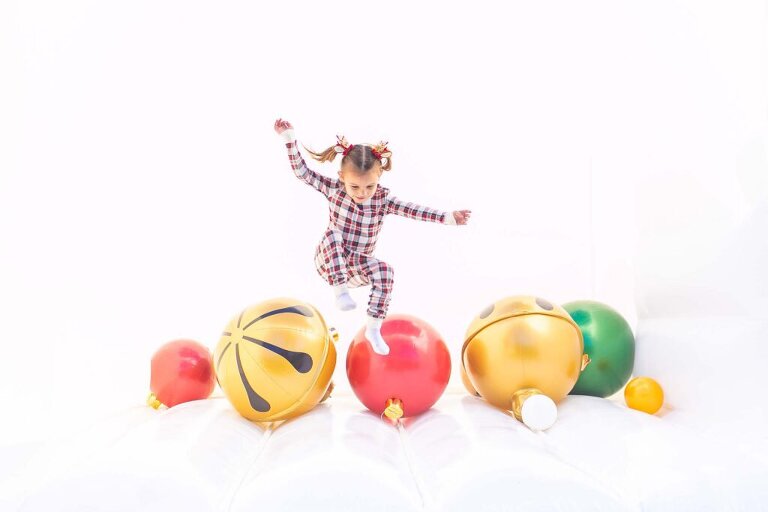 little girl jumping in a white bounce house during our christmas mini sessions