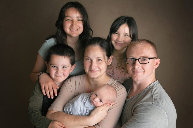 Mother and father with their 3 older children and their newborn