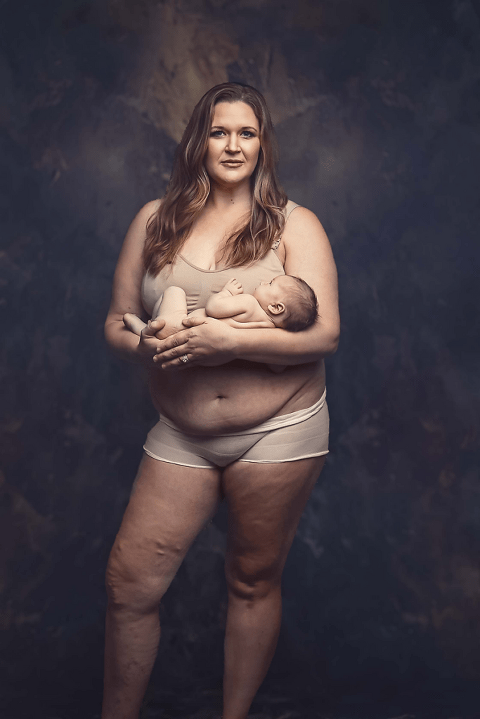 Raw image of a mother post partum, in her underwear and nursing bra, holding her newborn baby 