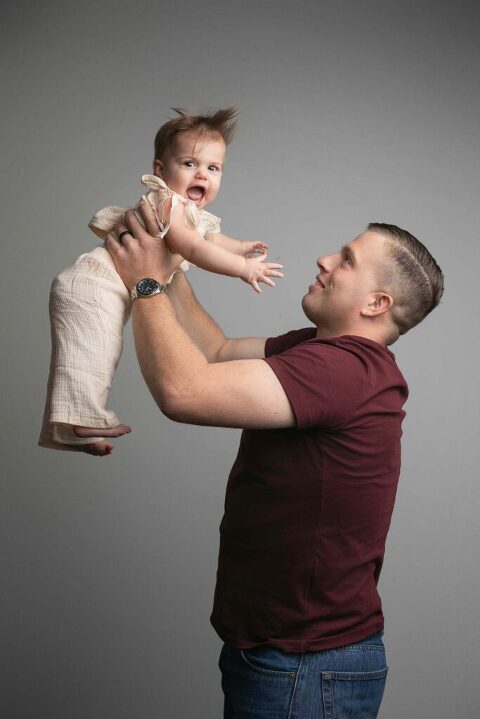 Dad throwing his little girl in the air for their picture