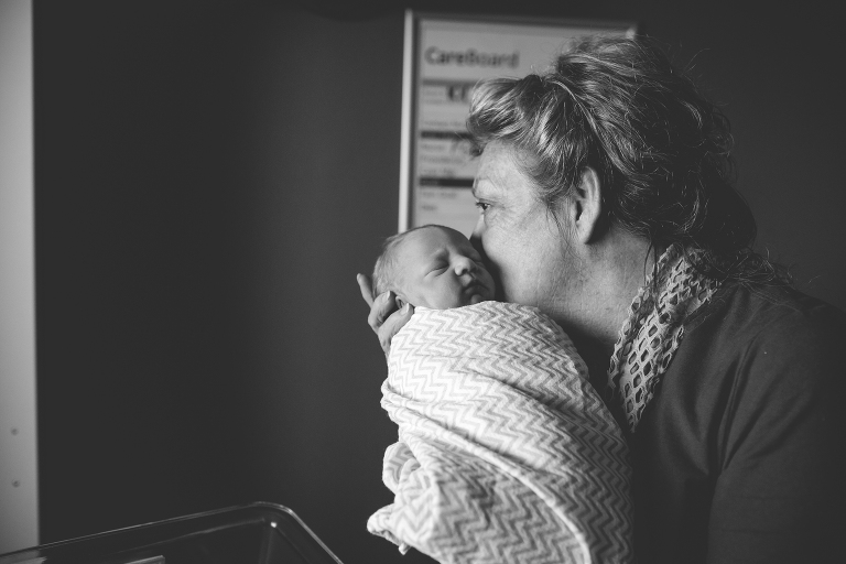 Great grandmother whispering into her great grandsons ear during his fresh48 session at Beaufort memorial hospital 